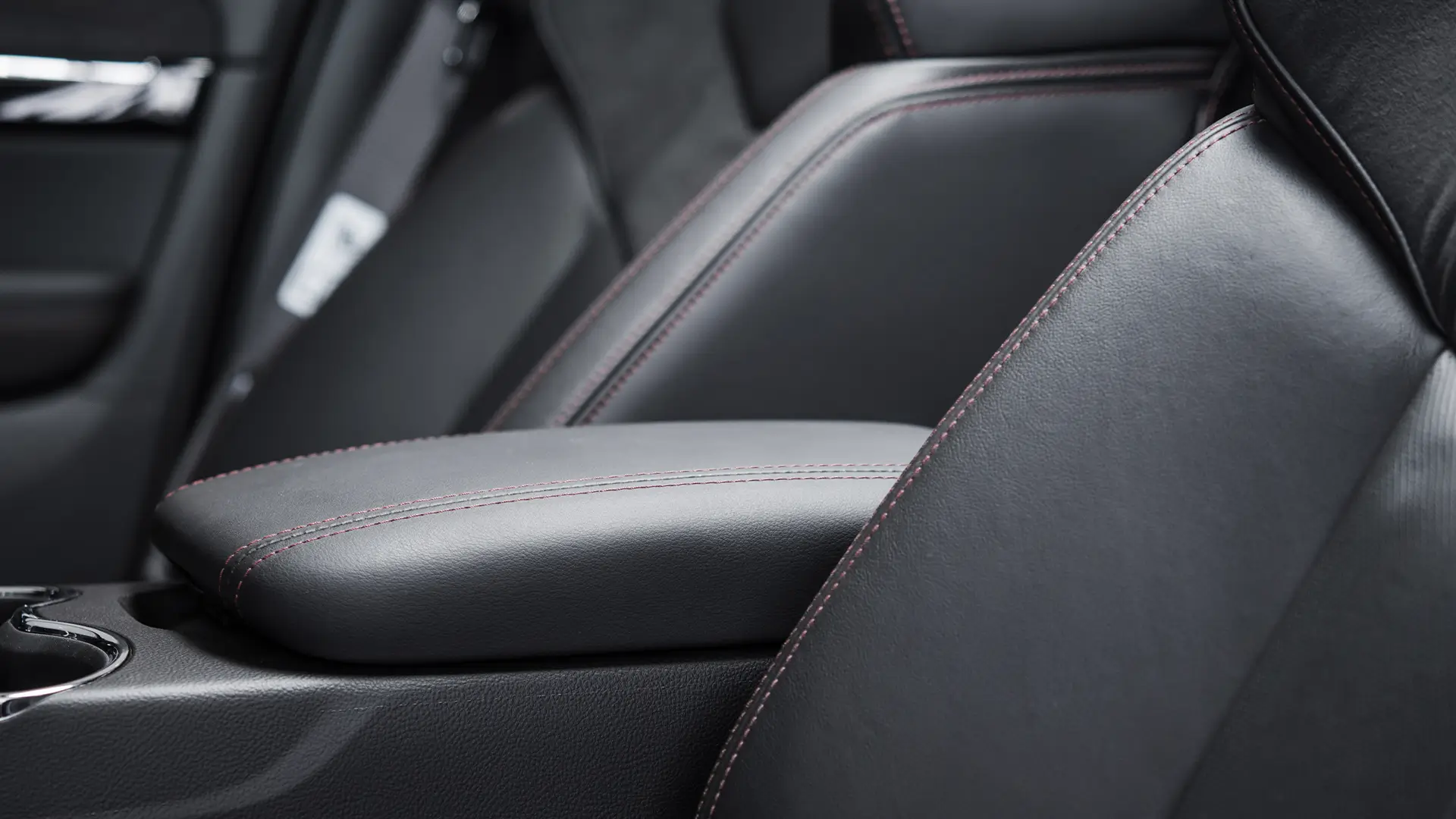 automotriz de auto por dentro con cuero negro y detalles de costura rojas